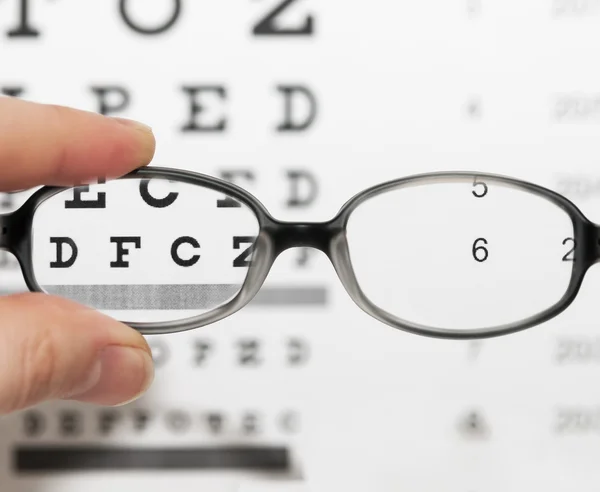 Glasses on eye chart — Stock Photo, Image