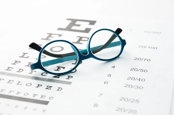 Glasses on eye chart — Stock Photo, Image