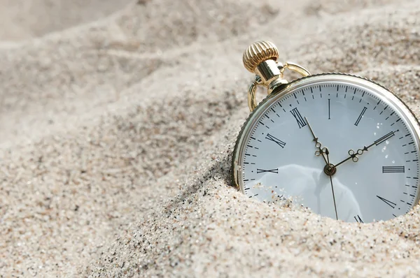 Pocket watch buried in sand Royalty Free Stock Images