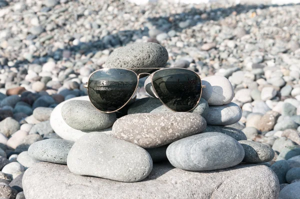 Óculos de sol em uma praia — Fotografia de Stock