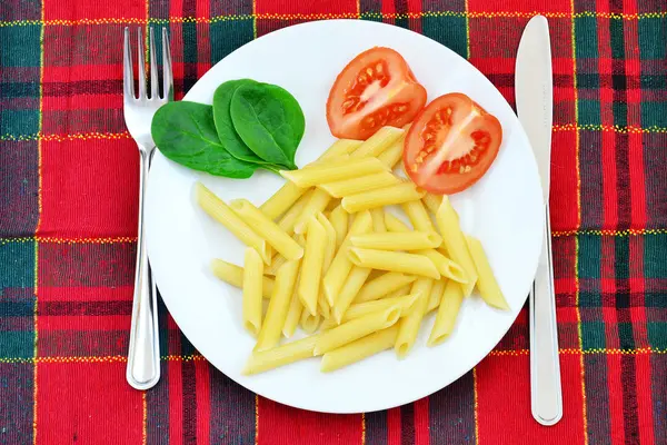 Massas, tomates e espinafres no prato — Fotografia de Stock