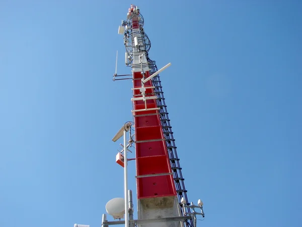 O topo de uma coluna de telecomunicações em fundo céu azul — Fotografia de Stock