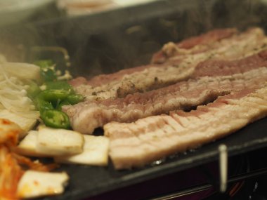grilled pork is on the pan in Thai style, Thai buffet with pork, chicken and other meats, cooked on brass barbecue pan, pork grill, Bar-B-Q, Thai Barbecue, Korean Barbecue in Thai Style, Thai Barbecue Buffet, Thai BBQ buffet, ThaiBBQ or Yakiniku food