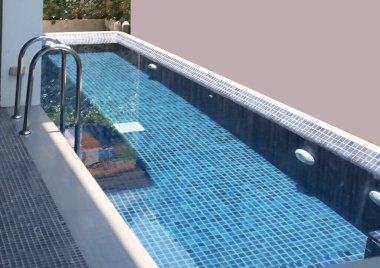 Yüzme havuzundaki temiz su mozaik merdivenlerle kaplıdır.