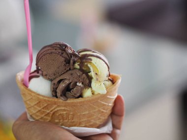 Çikolata, portakallı Tayland çayı, hindistancevizli dondurma kadın elinde çıtır waffle fincanı.