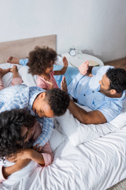 Neşeli Afro-Amerikalı çocuk. Annesine sarılıyor. Baba ve kızının yanında.