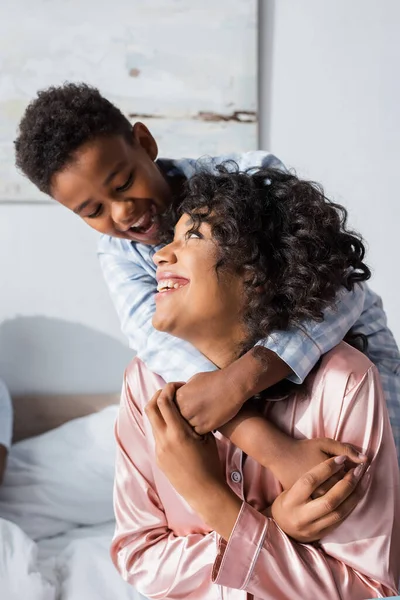 Cheerful African American Boy Embracing Happy Mother Bedroom — Stock Photo, Image
