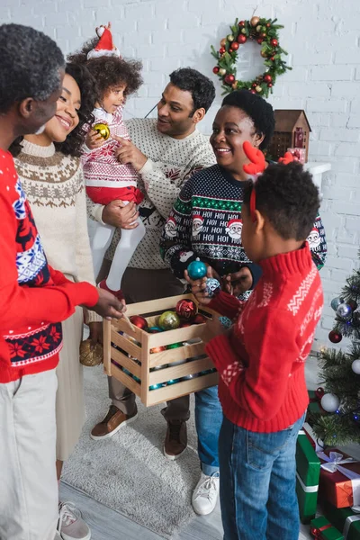 Joyful African American Family Choosing Christmas Balls Wooden Box Home — Stock Photo, Image