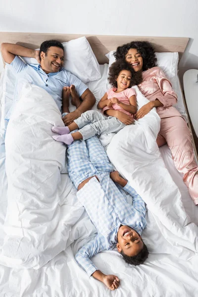 Vista Superior Alegre Familia Afroamericana Riendo Mientras Está Acostada Cama —  Fotos de Stock