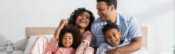 Feliz Casal Afro Americano Abraçando Crianças Alegres Quarto Bandeira — Fotografia de Stock