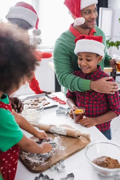 African American Man Orange Cinnamon Tea Embracing Excited Son Family — Stock Photo, Image