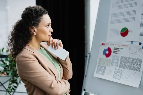 Thoughtful African American Businesswoman Mobile Phone Looking Flip Chart Analytics — Stock Photo, Image