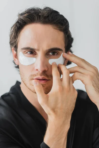 Jovem Roupão Preto Aplicando Adesivo Ocular Isolado Cinza — Fotografia de Stock