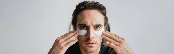 Young Man Looking Camera While Applying Eye Patches Home Banner — Stock Photo, Image