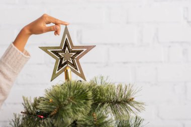 Afro-Amerikan kadının evdeki Noel ağacında yıldıza dokunduğu görüntüler. 