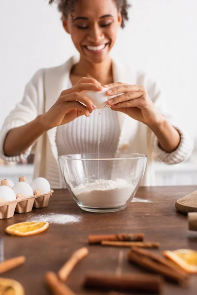 Mujer Afroamericana Borrosa Vertiendo Huevo Harina Cerca Palitos Canela Cocina — Foto de Stock