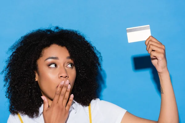 Изумленная Африканская Американка Закрывающая Рот Рукой Держа Кредитку Синем — стоковое фото