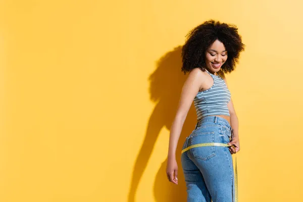 Mujer Afroamericana Delgada Alegre Pantalones Vaqueros Camiseta Que Mide Las —  Fotos de Stock