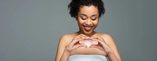 Radostná Afroamerická Žena Držící Kosmetickou Houbu Tvaru Srdce Izolovanou Šedém — Stock fotografie