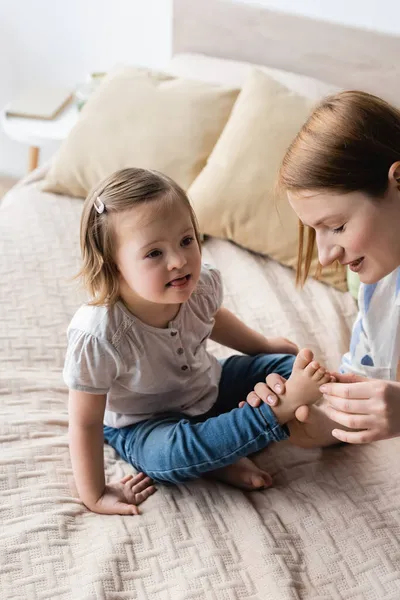 Lächelnde Mutter Berührt Füße Ihrer Kleinen Tochter Mit Syndrom Schlafzimmer — Stockfoto