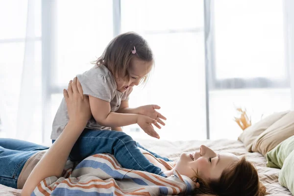 Madre Jugando Con Niña Alegre Con Síndrome Cama —  Fotos de Stock