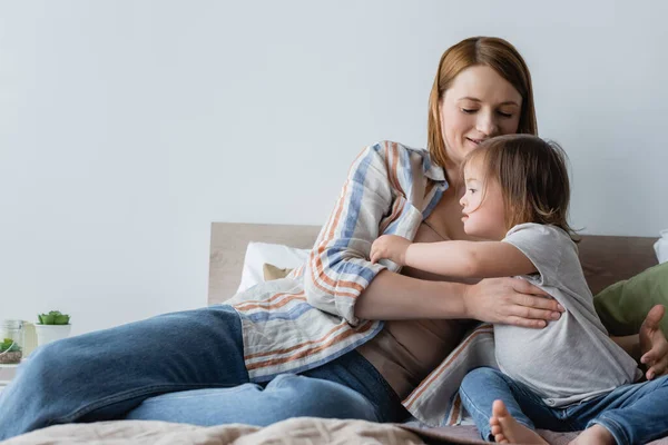 Sonriente Madre Tocando Hija Con Síndrome Cama Casa —  Fotos de Stock