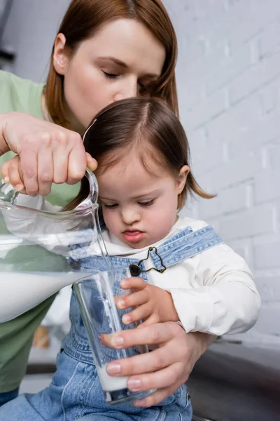 Mujer Vertiendo Leche Cerca Niño Con Síndrome Cocina — Foto de Stock