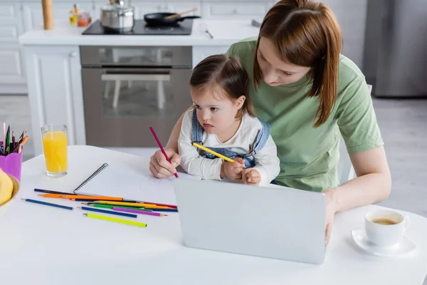 Child Syndrome Holding Color Pencil Mom Laptop Kitchen — Stock Photo, Image