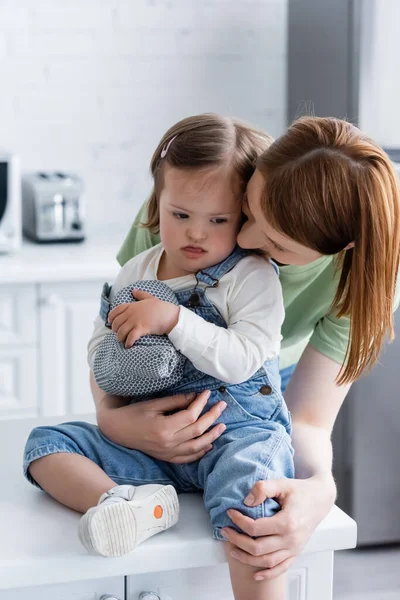 Madre Abrazando Hija Con Síndrome Sacando Lengua Sosteniendo Guante Hornear —  Fotos de Stock