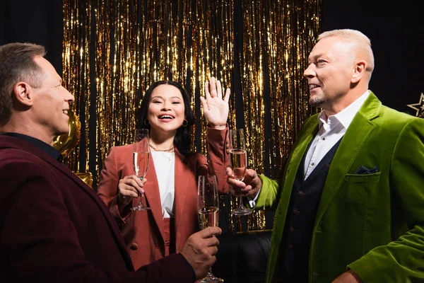 Sorridente Donna Asiatica Agitando Fotocamera Vicino Amici Con Bicchieri Champagne — Foto Stock