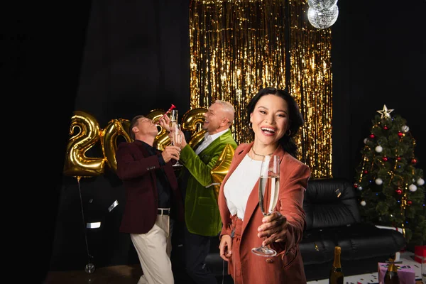Positive Asian Woman Holding Champagne Friends Party Horn Festive Decor — Stock Photo, Image