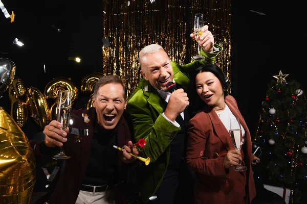 Felices Amigos Interracial Sosteniendo Cuernos Fiesta Champán Mientras Cantan Karaoke —  Fotos de Stock