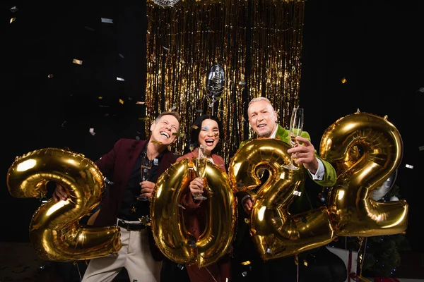 Happy Multiethnic Mature Friends Holding Champagne Balloons Shape 2022 Black — Stock Photo, Image