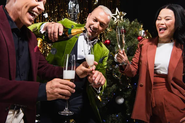 Maturo Uomo Versando Champagne Vicino Eccitato Interrazziale Amici Albero Natale — Foto Stock