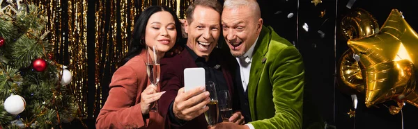 Positiv Mann Som Tar Selfie Nær Flerkulturelle Venner Med Champagne – stockfoto