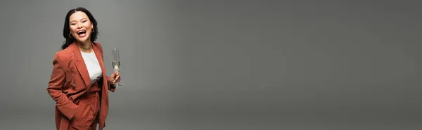 Возбужденная Азиатка Куртка Глядя Камеру Держа Бокал Шампанского Изолирован Сером — стоковое фото