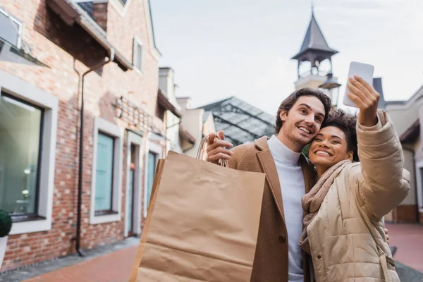 Mujer Afroamericana Feliz Tomando Selfie Con Novio Sosteniendo Bolsas Compras —  Fotos de Stock