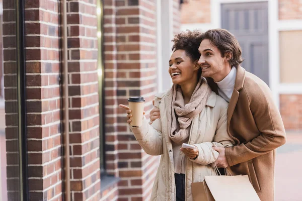 Mujer Afro Americana Feliz Con Taza Papel Apuntando Edificio Cerca — Foto de Stock