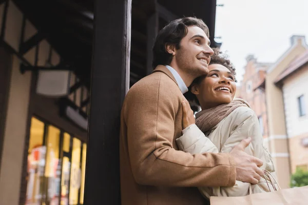 Laag Hoek Uitzicht Van Opgewonden Interraciale Paar Knuffelen Buurt Winkelcentrum — Stockfoto