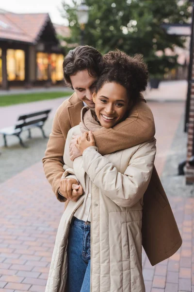 Sorridente Homem Abraçando Feliz Afro Americano Namorada Perto Construção Livre — Fotografia de Stock