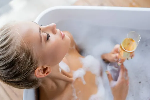 Vista Superior Jovem Mulher Loira Tomando Banho Segurando Copo Champanhe — Fotografia de Stock