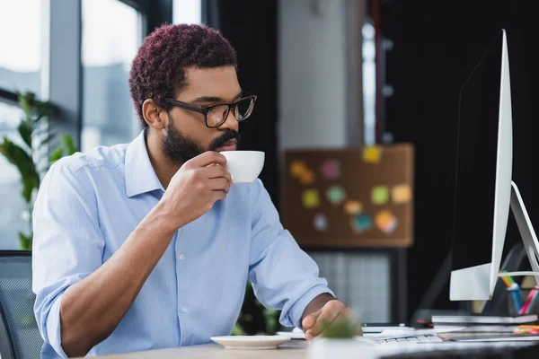 Joven Hombre Negocios Afroamericano Sosteniendo Taza Cerca Monitor Computadora Oficina — Foto de Stock