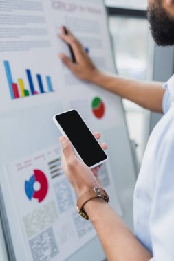 Afrika kökenli Amerikalı iş adamının ofisinde cep telefonu tutarken görüntüsü bulanık. 
