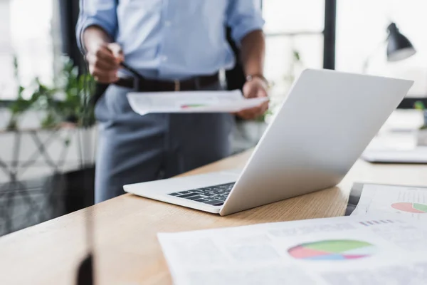 Ausgeschnittene Ansicht Des Laptops Der Nähe Von Dokumenten Und Verschwommene — Stockfoto