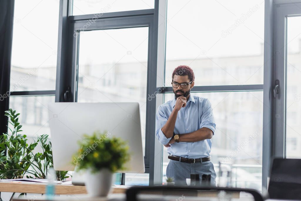 Concentrated african american businessman looking at computer monitor in office 