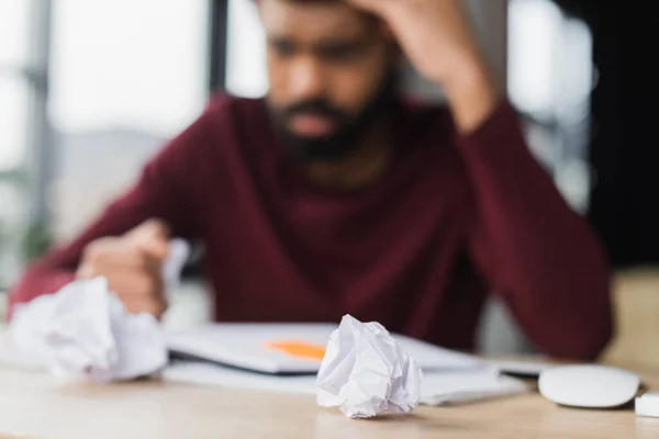 Zgnieciony Papier Pobliżu Zamazanego Afrykańskiego Biznesmena Biurze — Zdjęcie stockowe