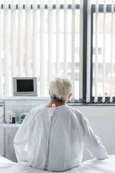 Обратный Вид Пожилого Пациента Халате Сидящего Кровати Больничном Отделении — стоковое фото