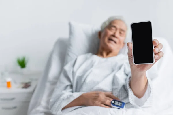Smartphone Mano Paciente Asiático Borroso Con Oxímetro Pulso Sala Hospital — Foto de Stock