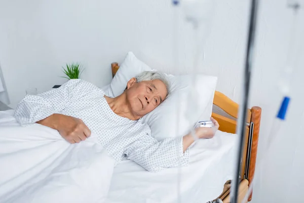 Idősebb Ázsiai Férfi Pulzoximéterrel Homályos Intravénás Terápia Mellett Fekszik Ágyon — Stock Fotó