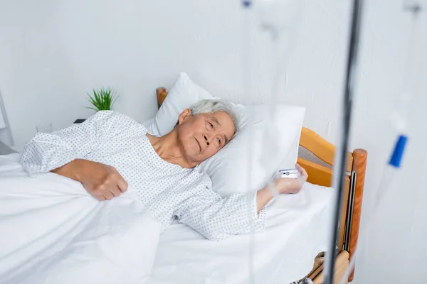 Senior Uomo Asiatico Con Pulsossimetro Sdraiato Vicino Offuscata Terapia Endovenosa — Foto Stock